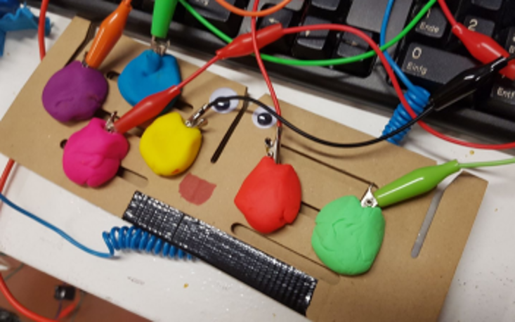 Selbst gebastelter Controller aus Knete mit der Makey-Makey-Platine, an der leitfähige Materialien angeschlossen werden können, um Tastaturfunktionen zu übernehmen. 