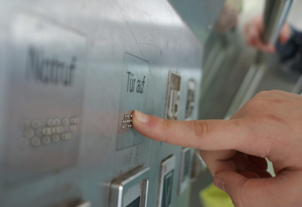 Aufzugbeschriftung "Tür auf" auch in Brailleschrift